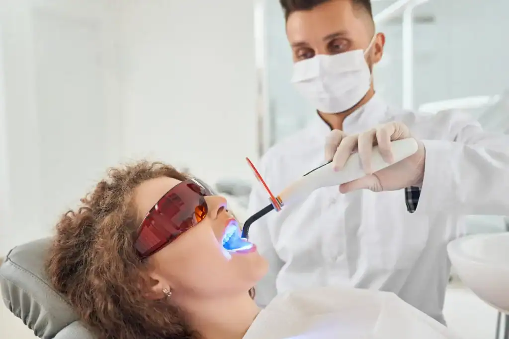 Woman receiving professional Laser Teeth Whitening treatment with safety glasses Marlow
